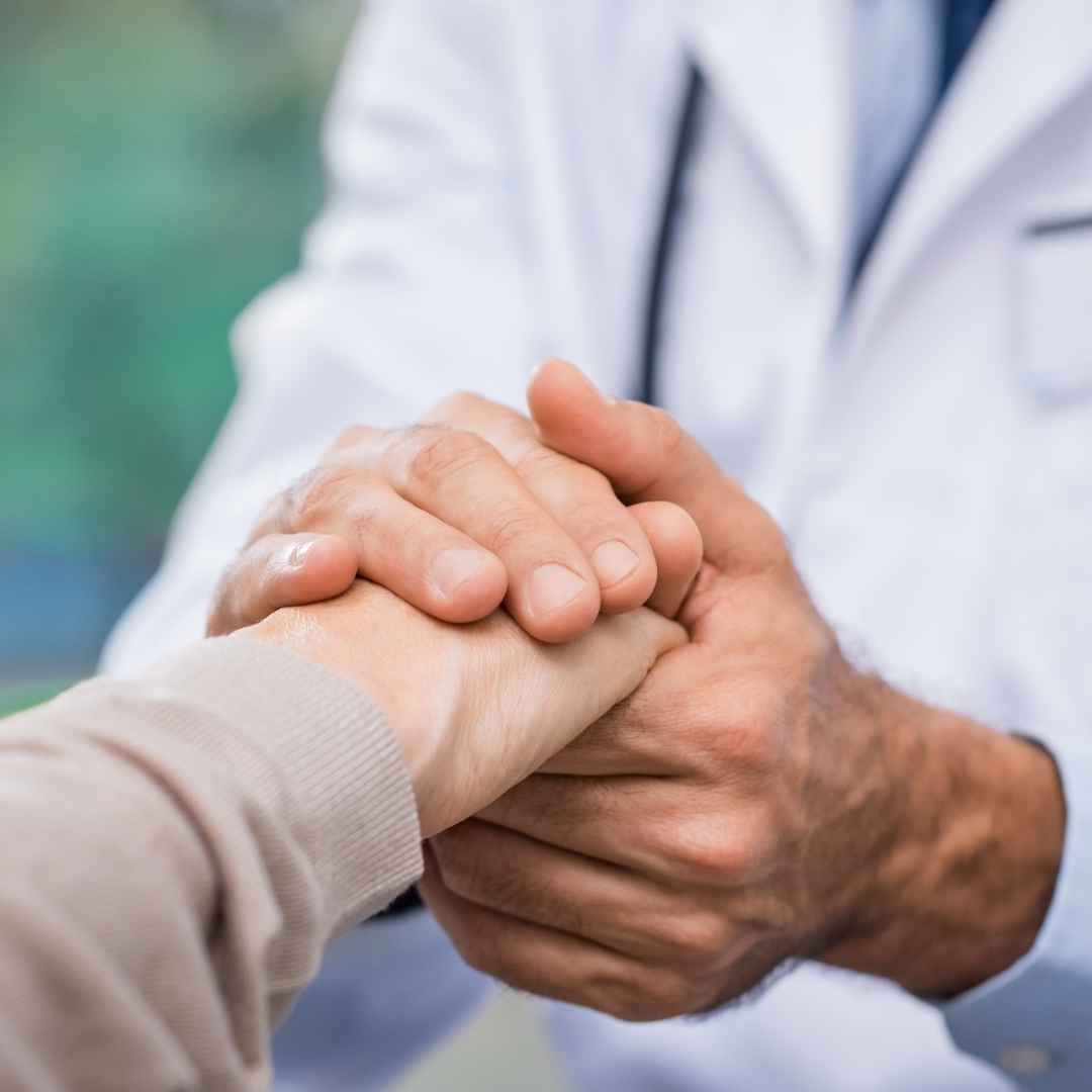 Doctor holding hands with patient