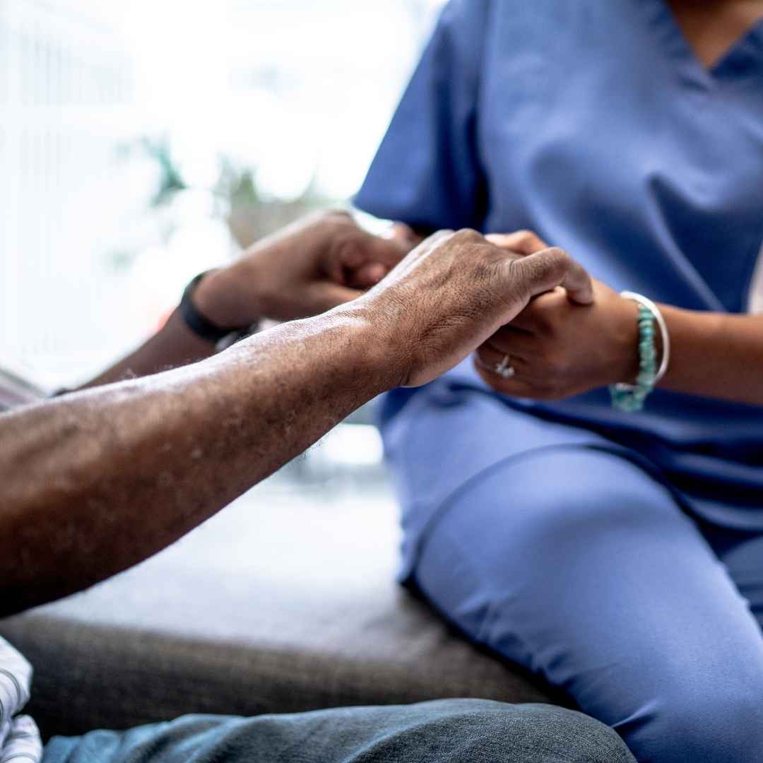 Nurse holding hands with patient.